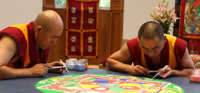 Tibetan Buddhist monks Gen Norbu (left) and Geshe Sangpo (right) construct a sand mandala for peace and healing.