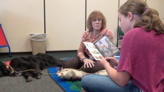 Burlington resident Kathleen Johns and Shaka, a registered therapy dog, volunteer each month with "Paws for Reading" in order to help kids with reading and self-confidence.
